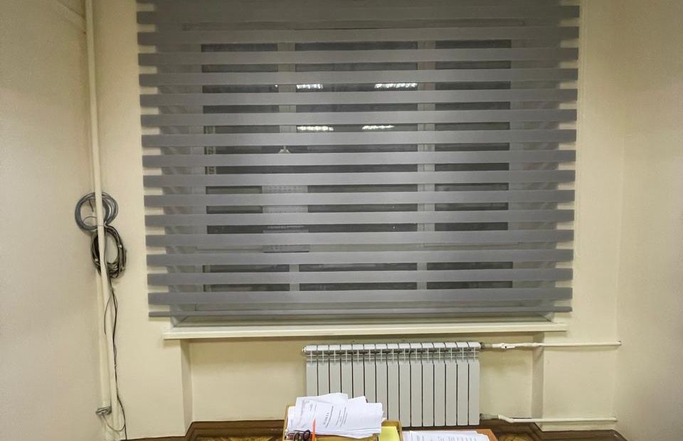 Рулонная жалюзи Зебра в кассете на проем окна в офисе